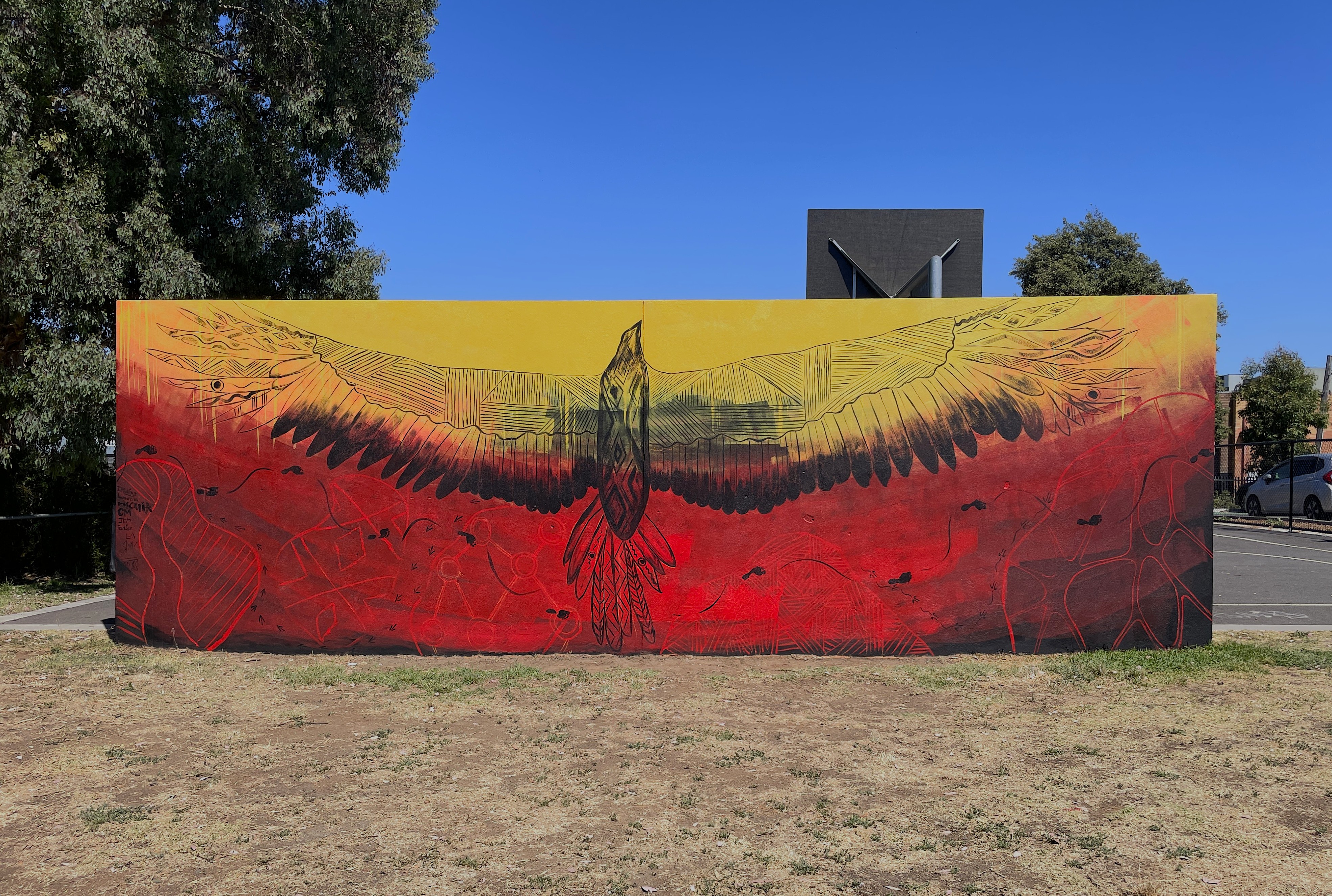 mural painting of Bunjil over red yellow and black