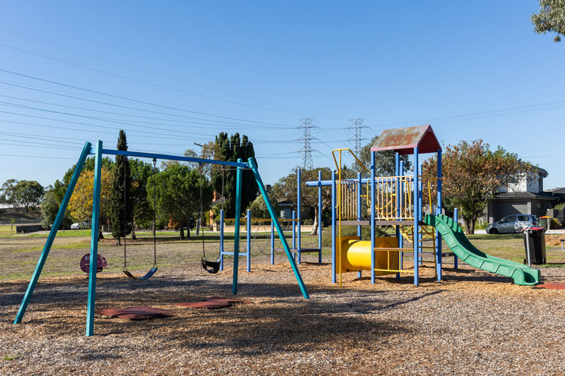 Children's playground with swings, climbing structures and slide.