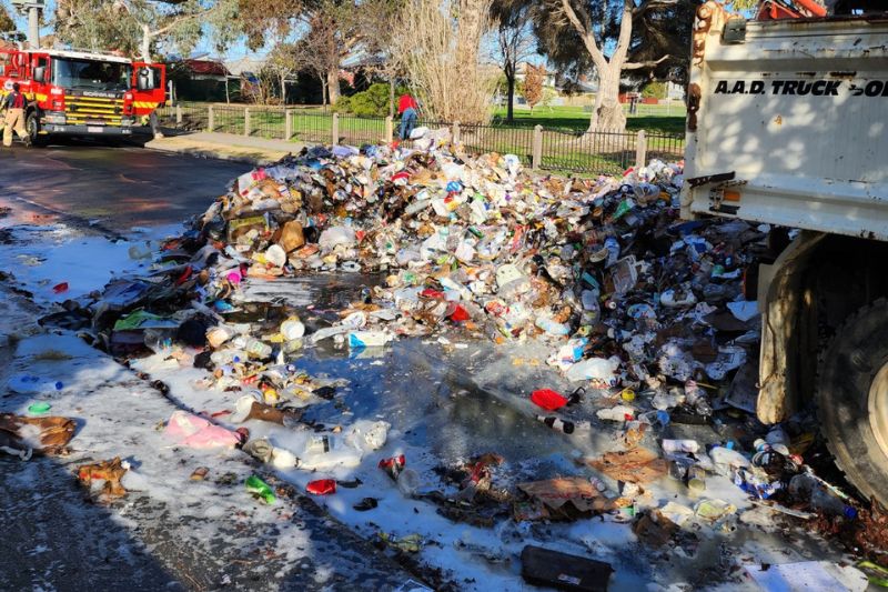 Waste is spread on the ground with a fire truck in the background.